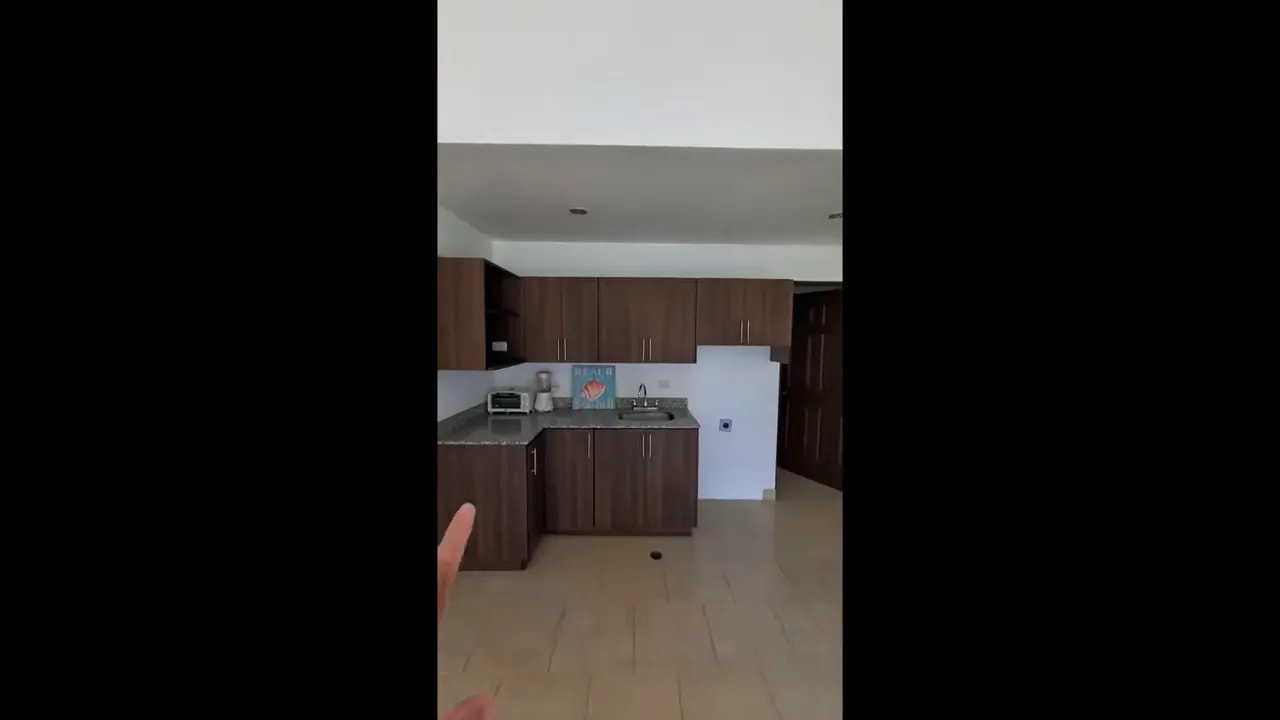 Kitchen with wood cabinets, granite countertop, sink, and white refrigerator