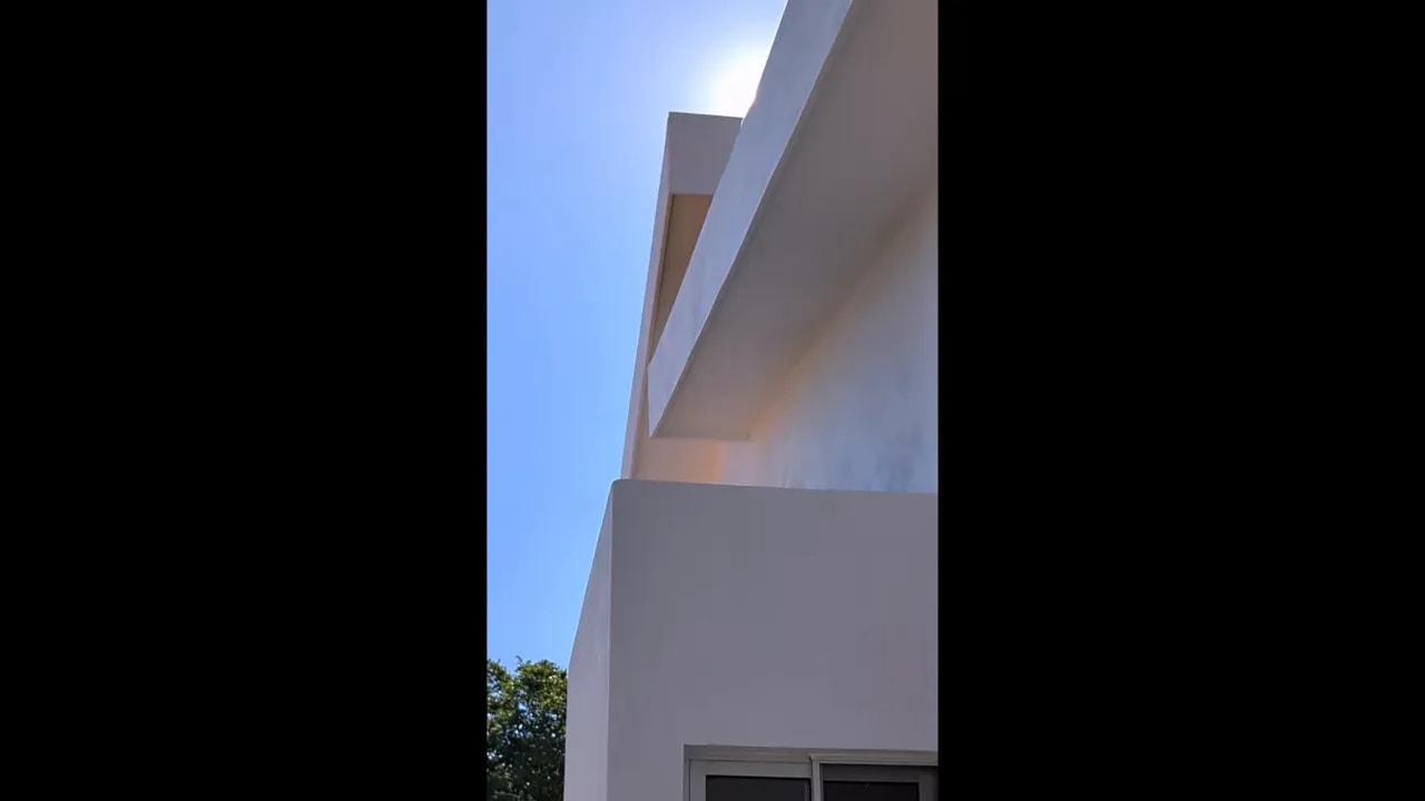 Side roof edge and wall junction in bright sunlight above a window